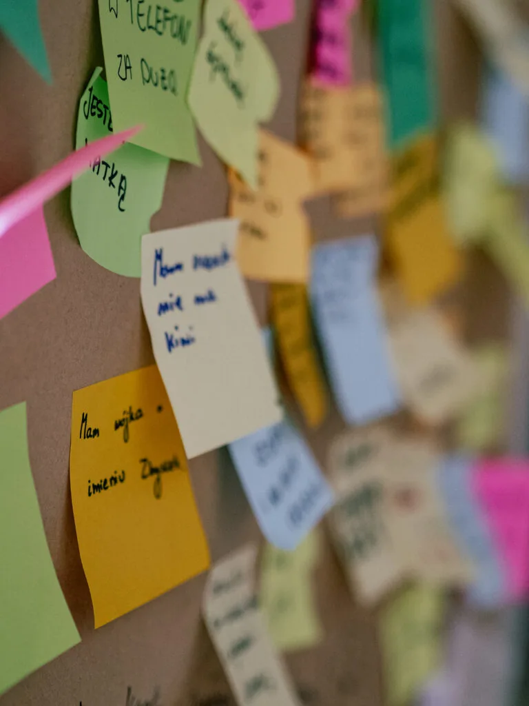 Zbliżenie na kolorowe karteczki. Część napisów wyraźna, inne zupełnie rozmazane.
